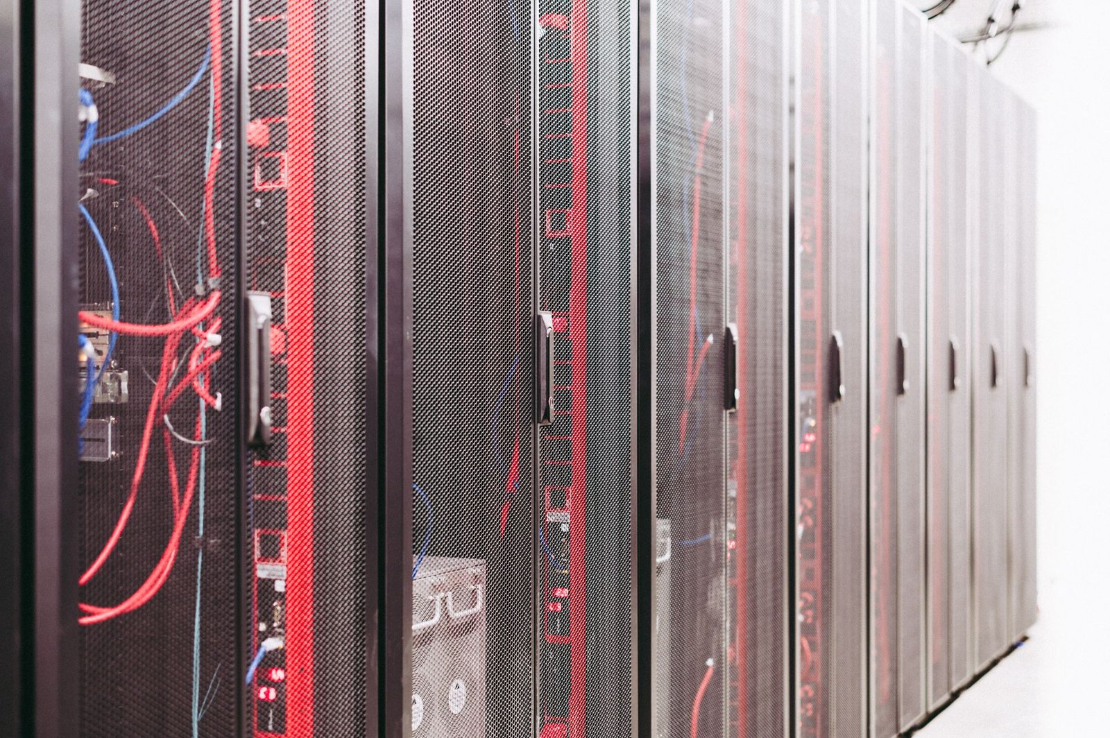 Fotografia de racks e cabeamento de rede, representando infraestrutura de TI